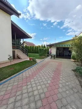 Pogled na popločano dvorište, garažu i spoljni deo kuće sa stepeništem. - image 7