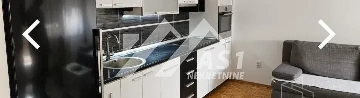 Kitchen equipped with white cabinets and built-in appliances.
