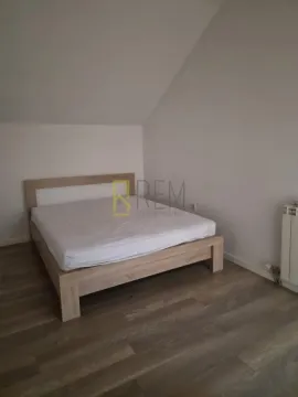 Bedroom with a double bed under a sloped ceiling. - image 6