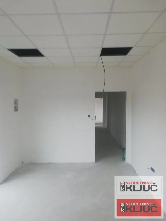 Empty room under construction with a drop ceiling.