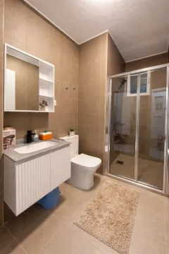 Moderno opremljeno kupatilo sa tuš kabinom i umivaonikom. - image 3