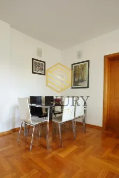 Dining area with a table and white chairs. - image 7