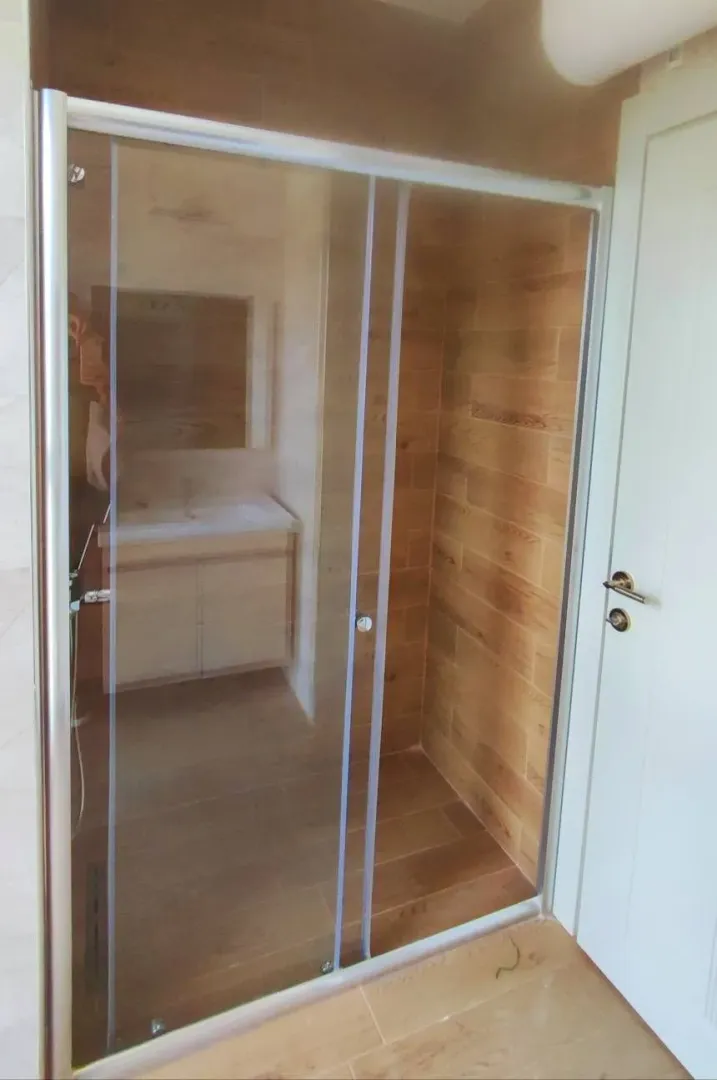 Modern bathroom with a walk-in shower and wood-effect tiles.