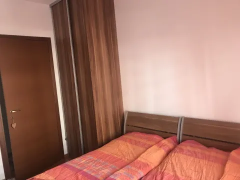 A bedroom with a double bed and a wooden wardrobe. - image 11