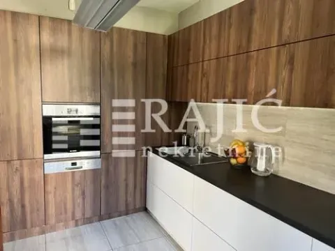 Moderna kuhinja sa tamnim drvenim elementima i ugrađenim aparatima. - image 10