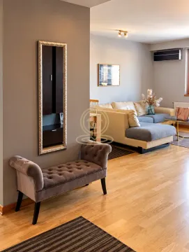 View from the hallway towards the living room with a sectional sofa and a wall mirror. - image 9