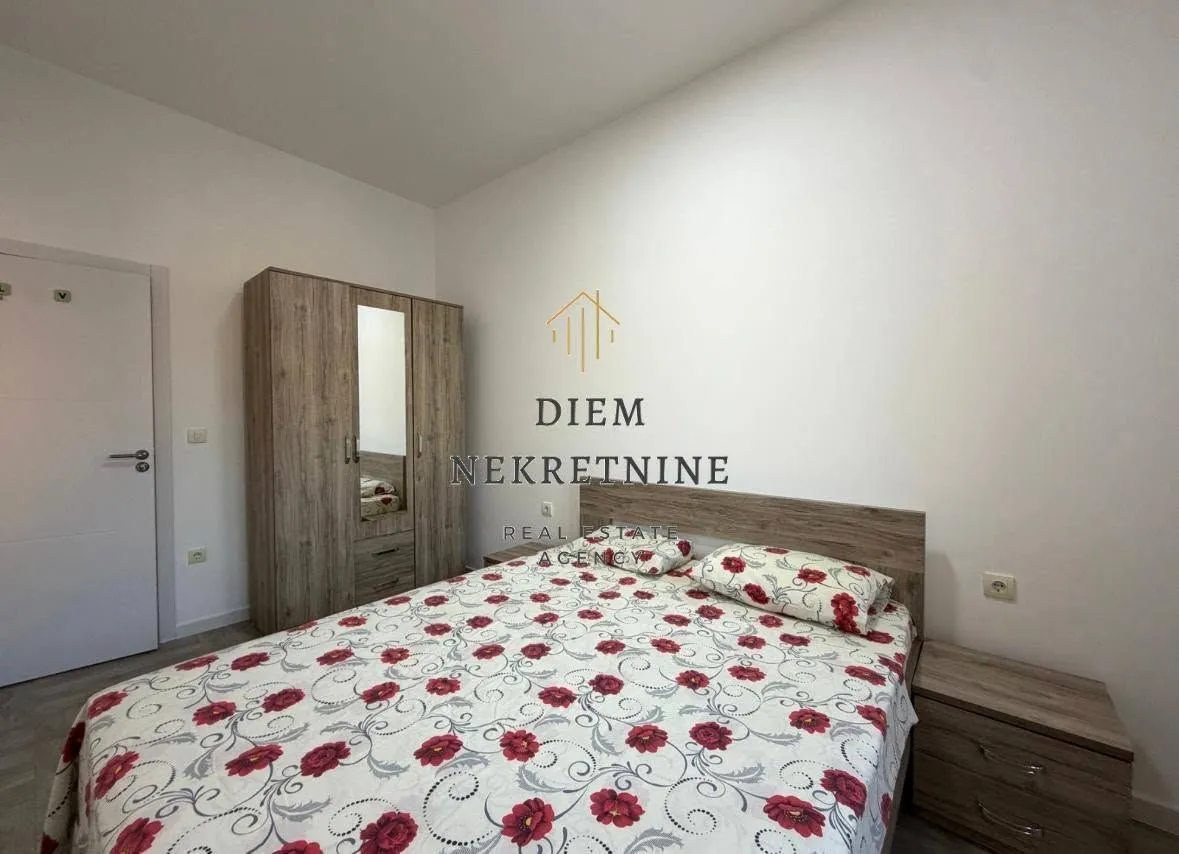 Furnished bedroom with a double bed, wardrobe, and nightstand.