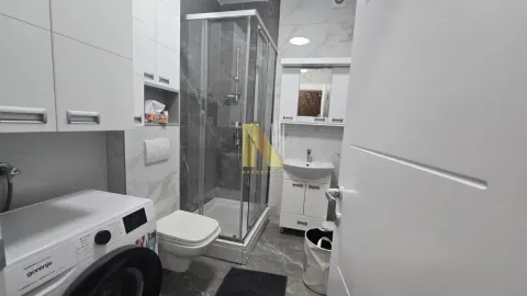 Savremeno opremljeno kupatilo sa tuš kabinom, umivaonikom i veš mašinom. - image 11