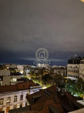 Noćni pogled sa prozora na gradske krovove i osvetljene ulice. - image 21