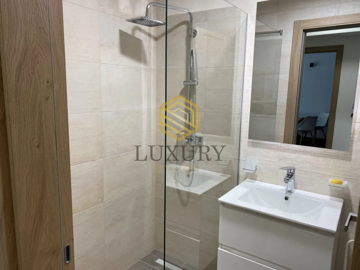 Modernly equipped bathroom with a walk-in shower and washbasin.