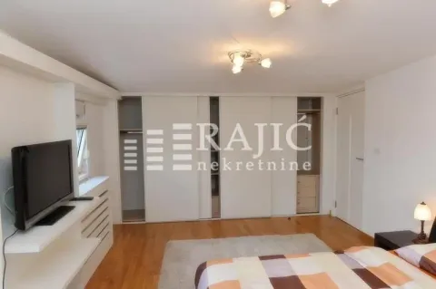 Furnished bedroom with a large wardrobe and television. - image 14