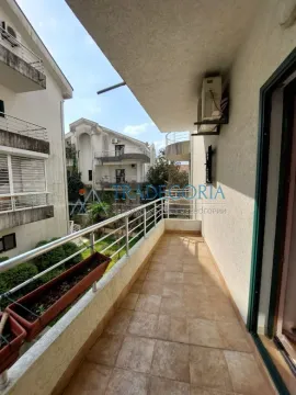 Dugačak popločani balkon sa metalnom ogradom i pogledom na okolne zgrade. - image 24