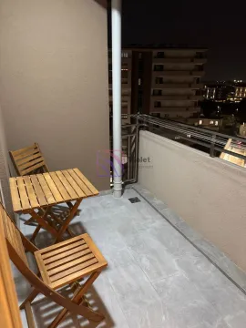 Natkriveni balkon sa drvenim stolom i stolicama noću. - image 12