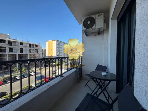 Small furnished balcony with a table, chairs, and air conditioning unit. - image 7