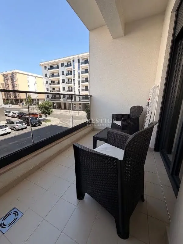 Covered terrace with outdoor seating furniture and a city view.