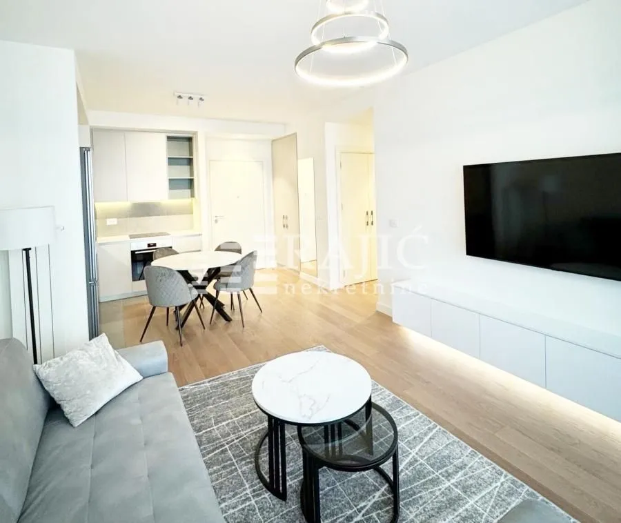Modern living room with dining area and kitchen in the background.