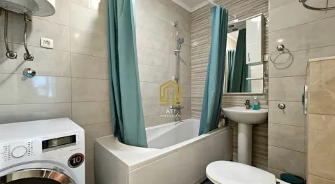 Compactly equipped bathroom with a bathtub, washbasin, and washing machine. - image 10