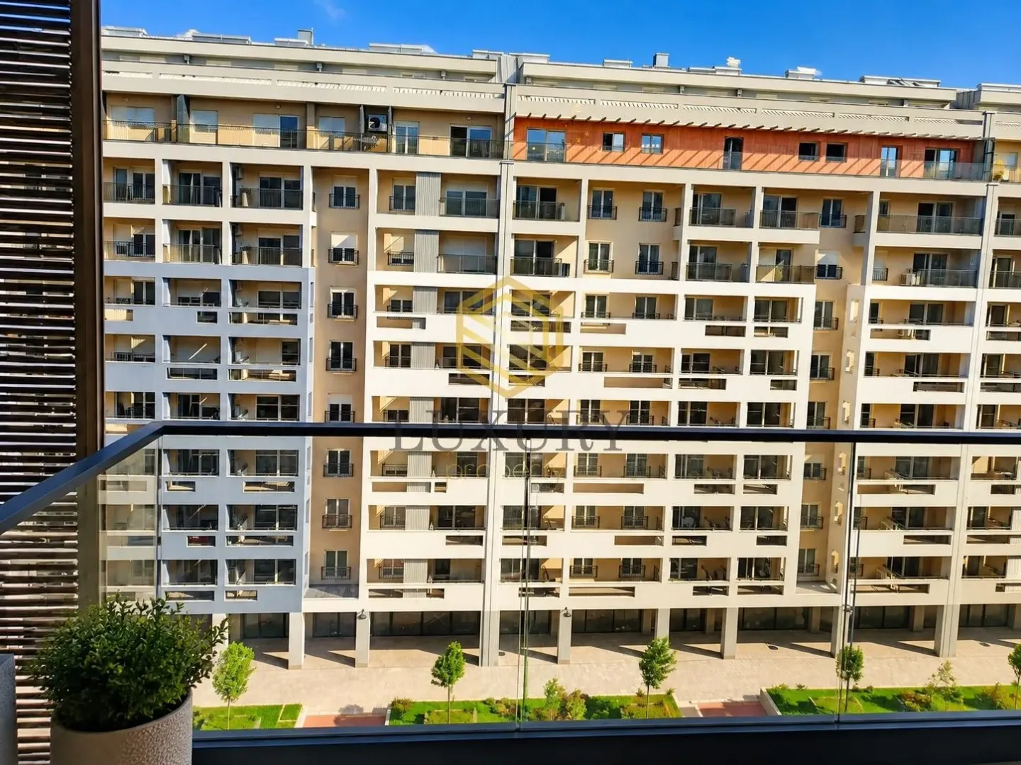 Pogled sa terase na fasadu moderne višestambene zgrade.