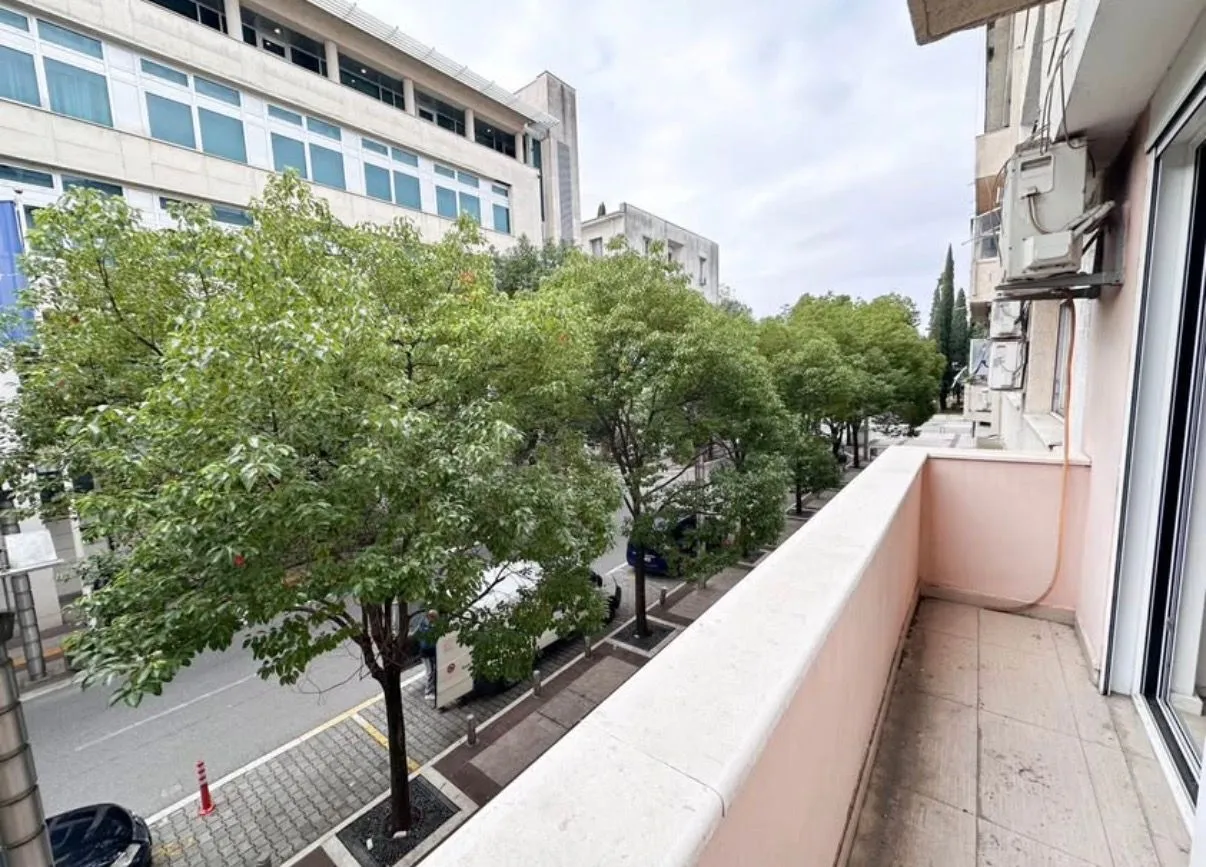Small balcony with a view of the street and trees.