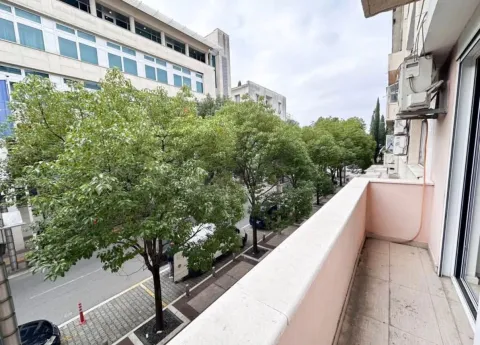 Small balcony with a view of the street and trees. - image 10