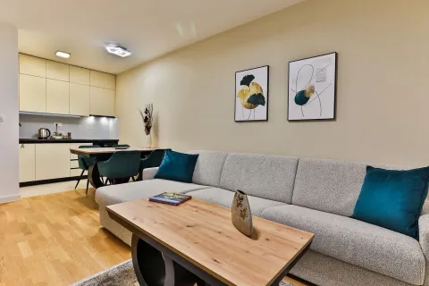 Living room with a sofa and dining area in an open-plan space. - image 4