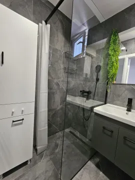 Moderne kupatilo sa tuš kabinom, umivaonikom i sivim pločicama. - image 2
