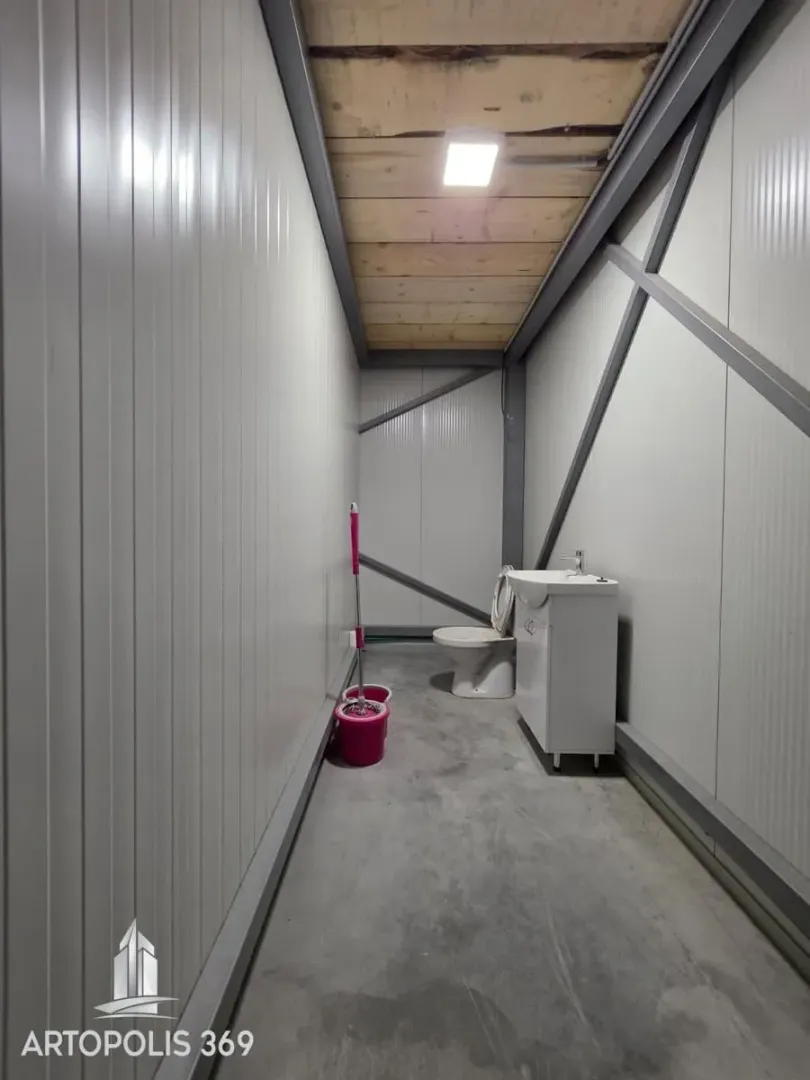 Auxiliary restroom in a hallway with a sink and a toilet bowl.