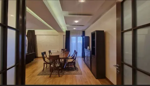 A spacious dining area with a wooden table and chairs, connected to the living room. - image 4