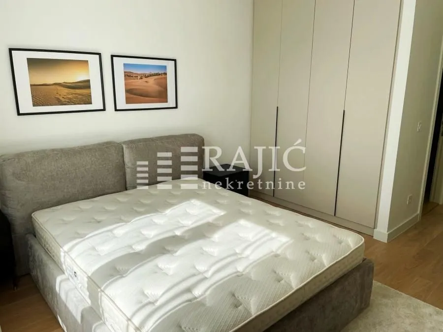 Bedroom with a double bed, wardrobe, and wall art.