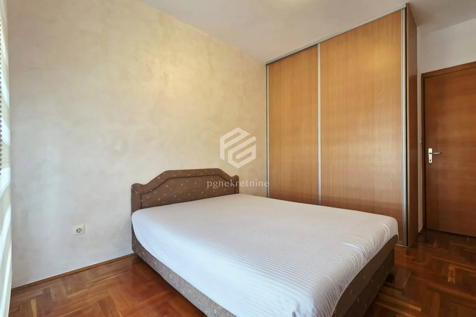 Furnished bedroom with a double bed and a built-in wardrobe.