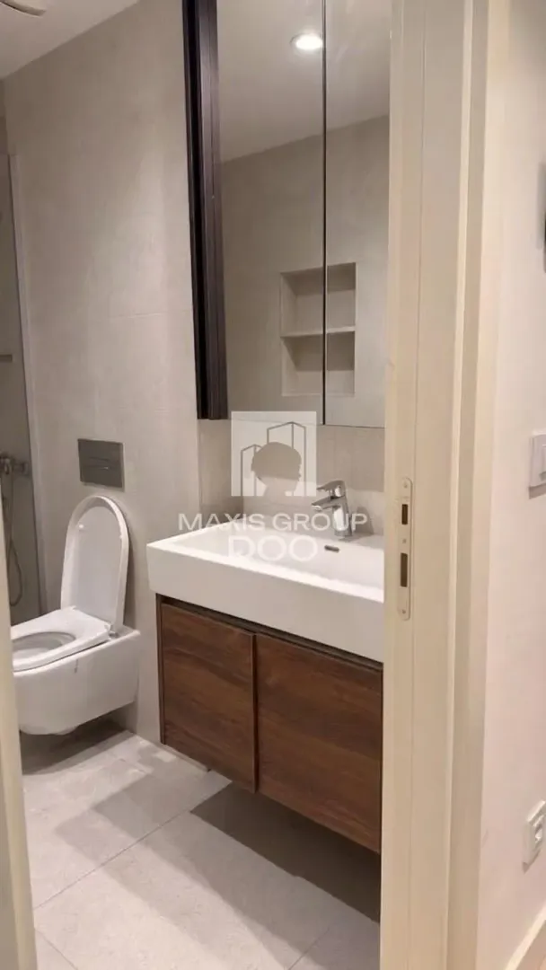 Modern bathroom with a washbasin, mirror, and toilet.
