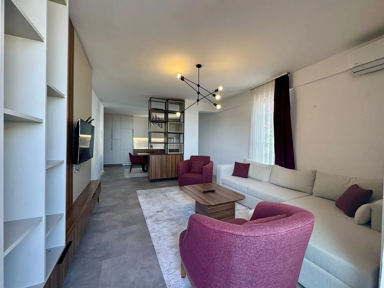 Modern living room with a sofa set and dining area in the background.