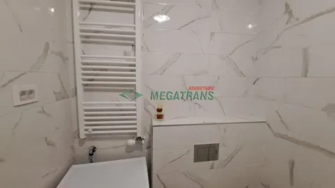 Kupatilo obloženo keramičkim pločicama sa mermernim dezenom i belim radijatorom. - image 18