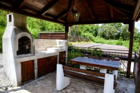 Natkriveni dio dvorišta sa roštiljem, sudoperom i drvenim stolom za sjedenje. - image 6