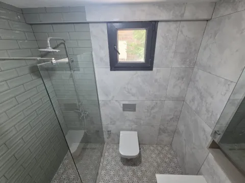Savremeno opremljeno kupatilo sa tuš kabinom i prozorom. - image 11