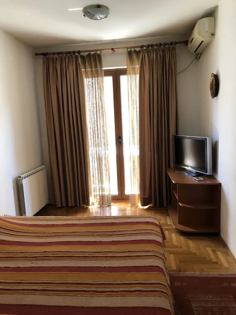 Bedroom with a TV and balcony access.