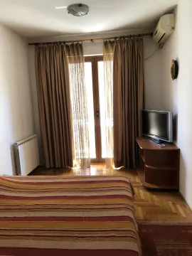 Bedroom with a TV and balcony access. - image 11