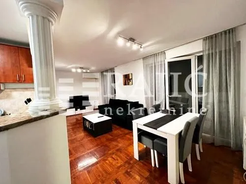 Living room with dining area and kitchen in the background.