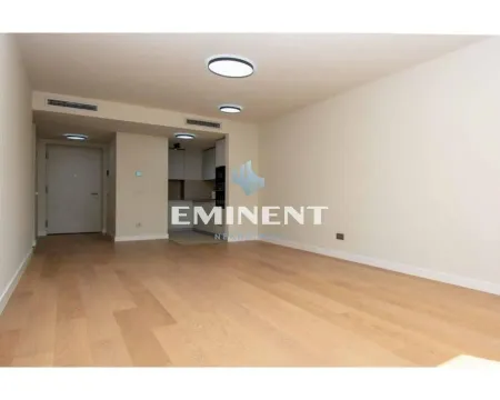 Empty living room with hardwood floors and a view of the kitchen in the background. - image 3
