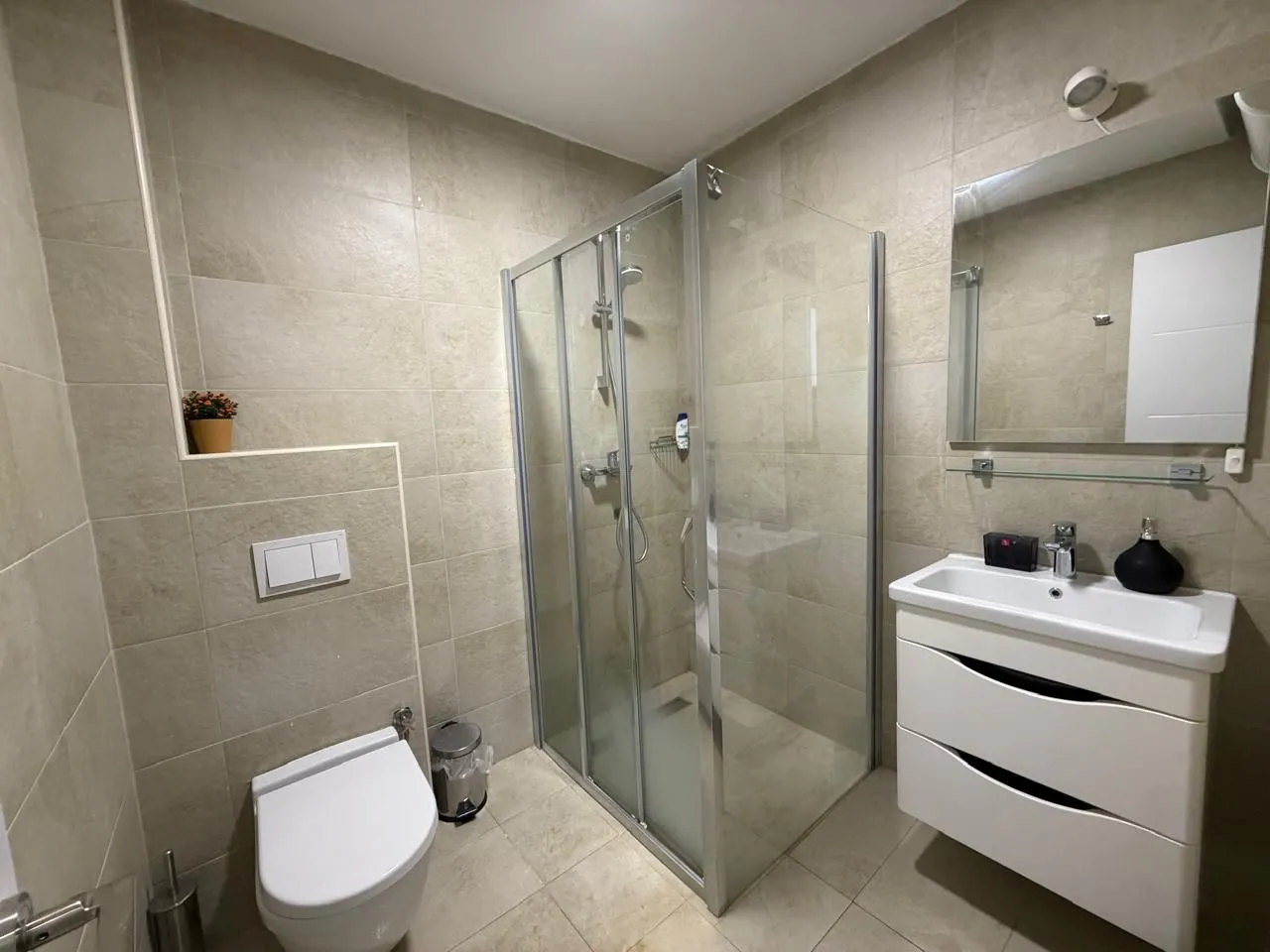 Modern bathroom equipped with a shower enclosure, washbasin, and toilet.