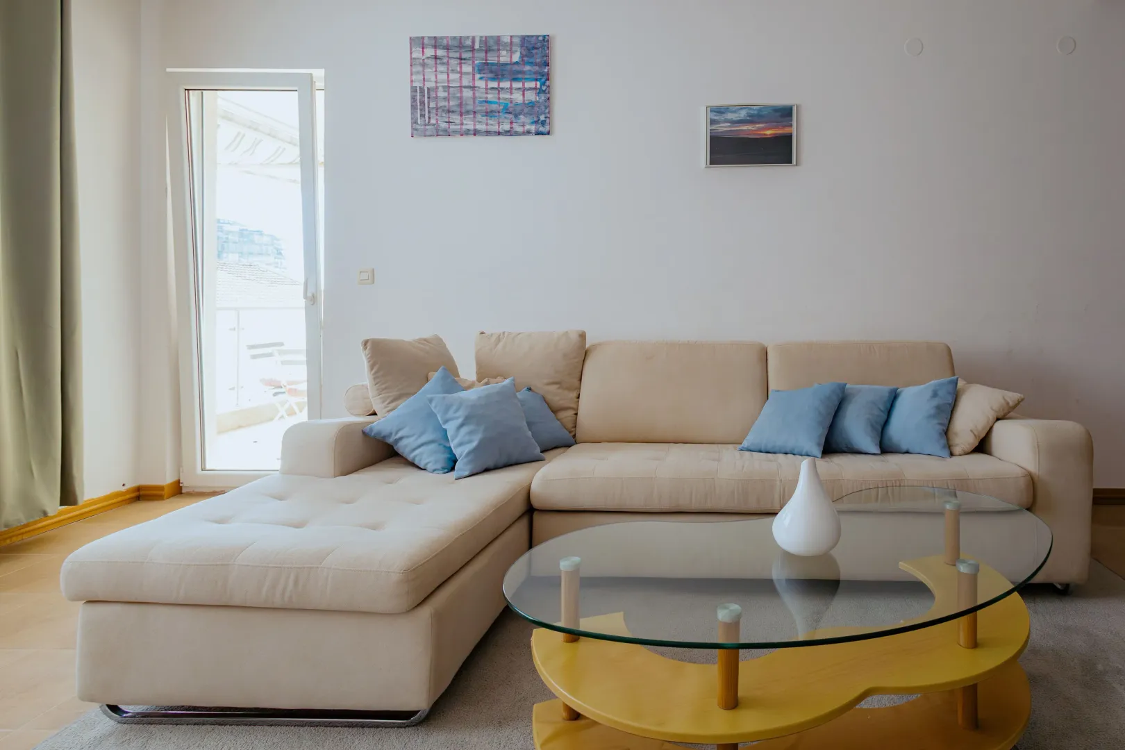 Living room with a sectional sofa and a glass coffee table.