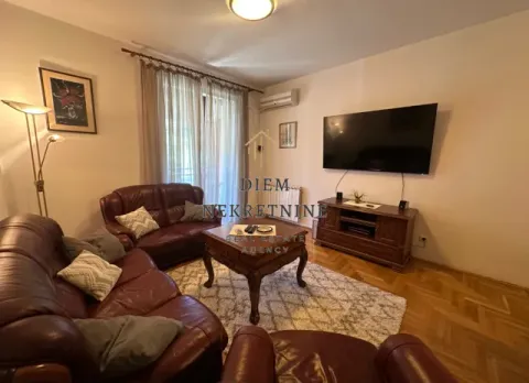 Furnished living room with leather sofas, TV, and parquet flooring. - image 9