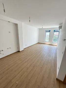 Empty room with white walls, wooden flooring, and two windows. - image 4