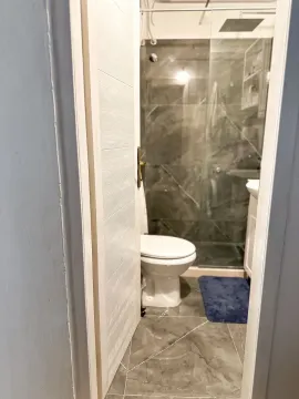 View from the hallway into a modern bathroom with a walk-in shower. - image 9