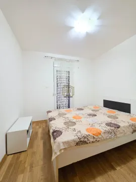 Namještena spavaća soba sa bračnim krevetom, bijelim zidovima i drvenim podom. - image 7