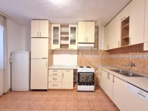 Kitchen equipped with light wooden cabinets, a stove, and a refrigerator. - image 3