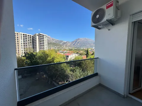 View from the balcony overlooking surrounding buildings and mountains. - image 10