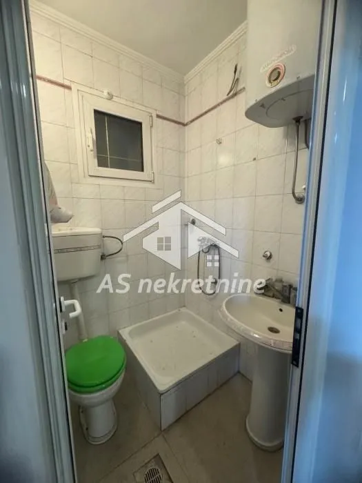 Small bathroom with a shower stall, washbasin and toilet.