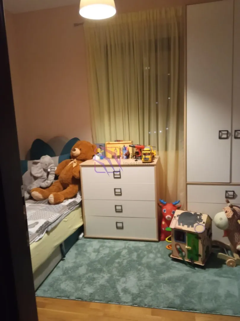 Dječja soba sa krevetom, komodom, ormarom i igračkama.