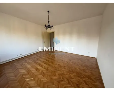 Empty room with parquet flooring and a chandelier on the ceiling. - image 2